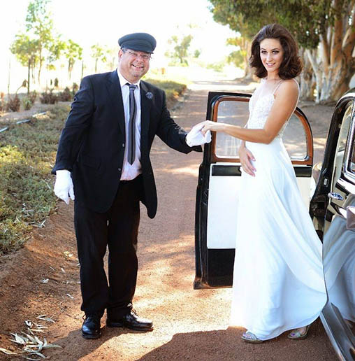 Friendly owner helping bride out of classic car